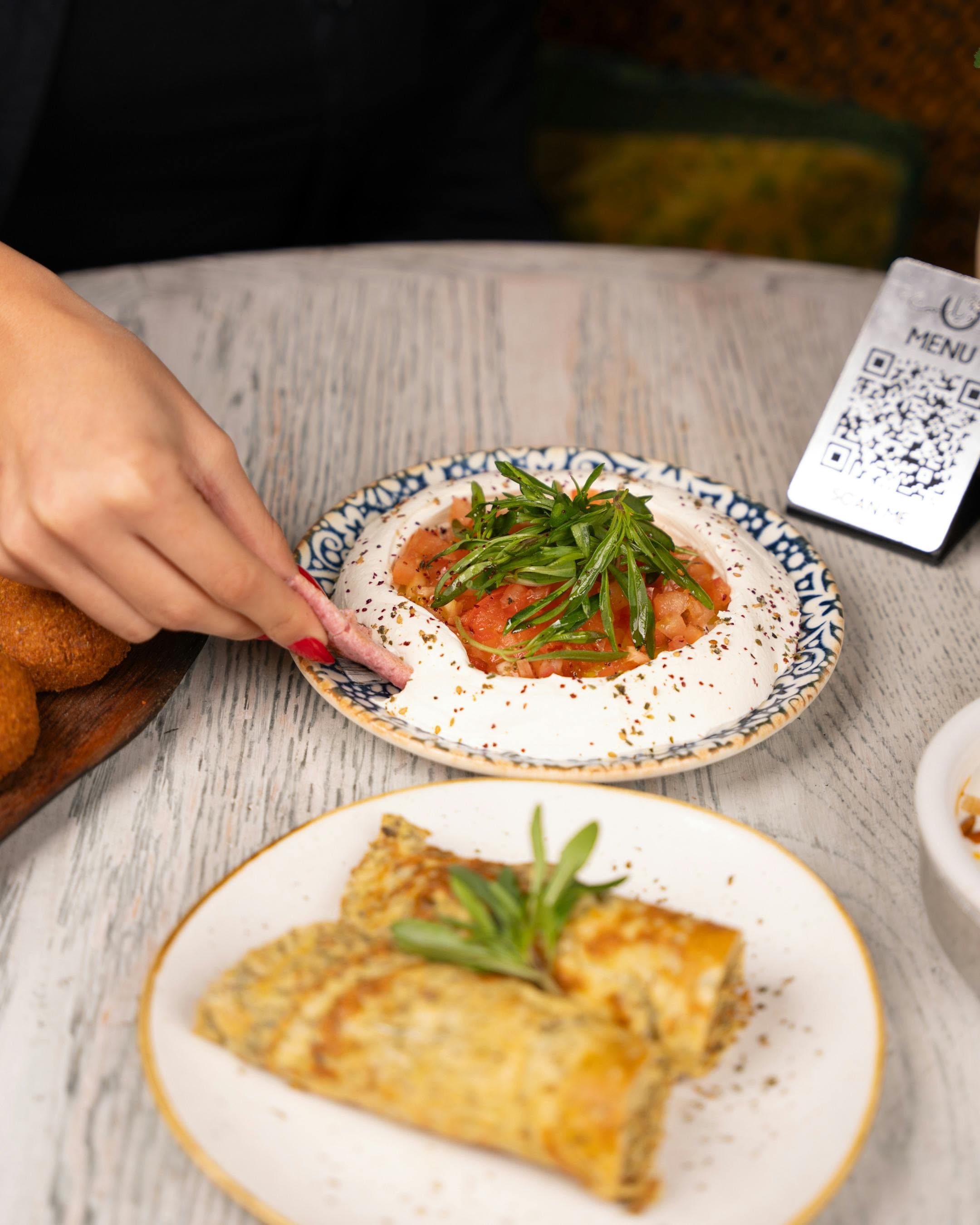 A guest ordering from their phone at a restaurant table using a QR code